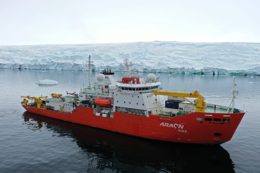 เรือตัดน้ำแข็ง Araon ของสถาบันขั้วโลกเกาหลี Korean Polar Research Institute (KOPRI) ขณะจอด ใกล้กับ Canisteo Peninsula บริเวณ Amundsen Sea, Antarctica โดยมี Changvan อยู่ด้านหน้าของเรือ